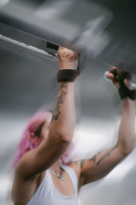 woman doing lifting straps with pull ups