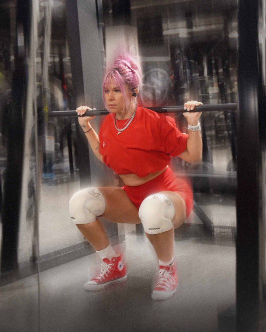 woman doing slow squat wearing uppper knee sleeves