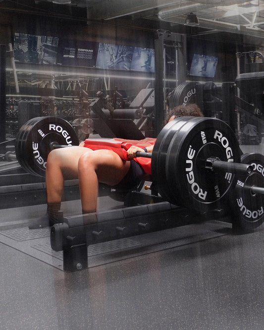 woman doing heavy hip thrust with uppper barbell pad
