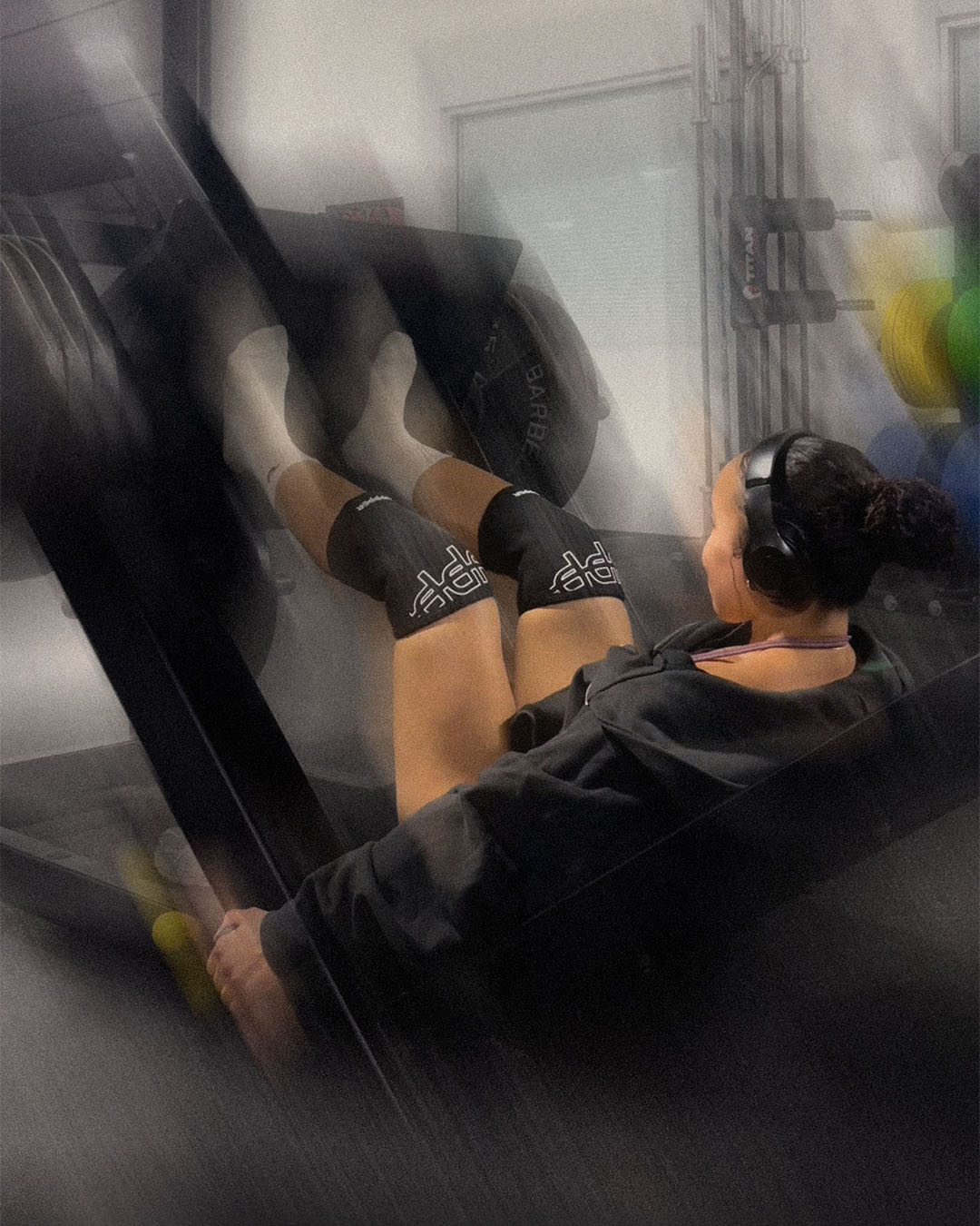 woman doing leg press wearing uppper knee sleeves