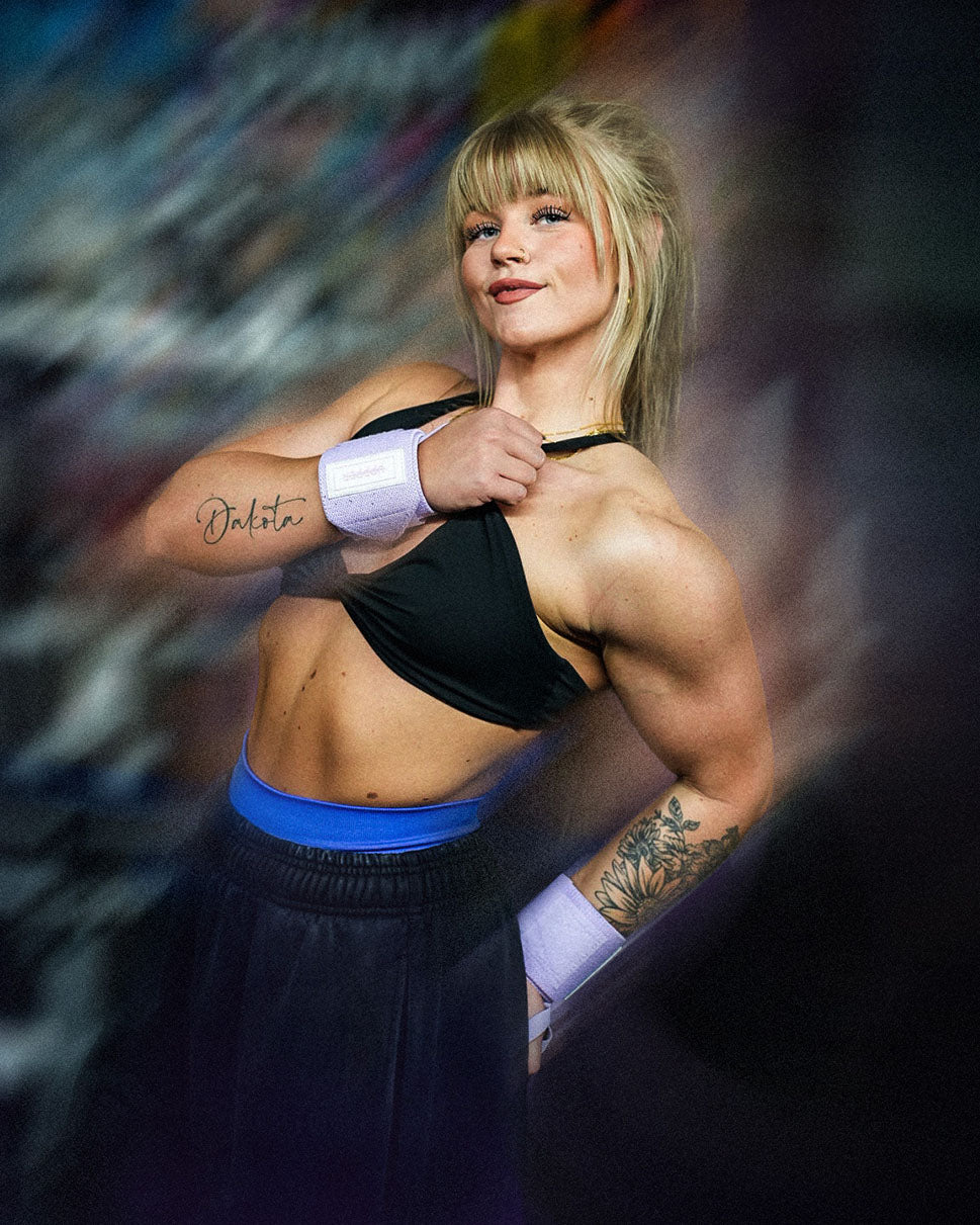 woman flexing deltoids wearing uppper wrist wraps